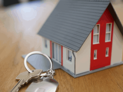 Miniature house with house key on a ring